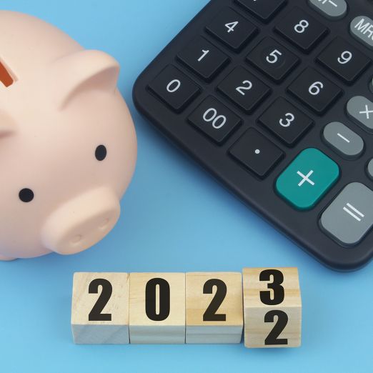 Imagebild shutterstock Jahresendgeschäft: Über der Jahreszahl 2023 stehen ein Sparschwein und ein Taschenrechner