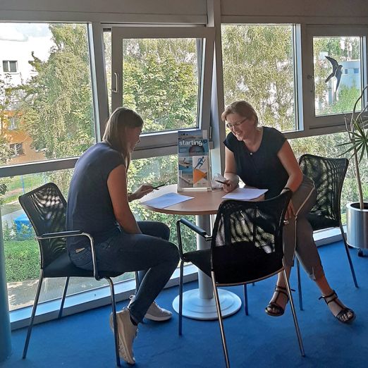 Zwei Frauen, die an einem Tisch sitzen und sich unterhalten