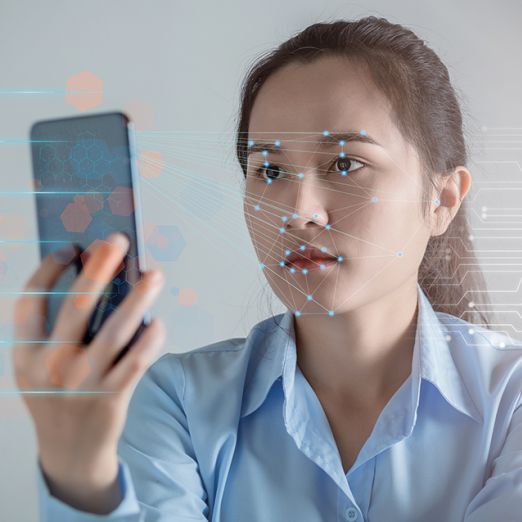 Frau scant Gesicht mit Handy
