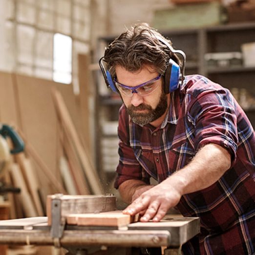 Tischler arbeitet an einer Holzsäge